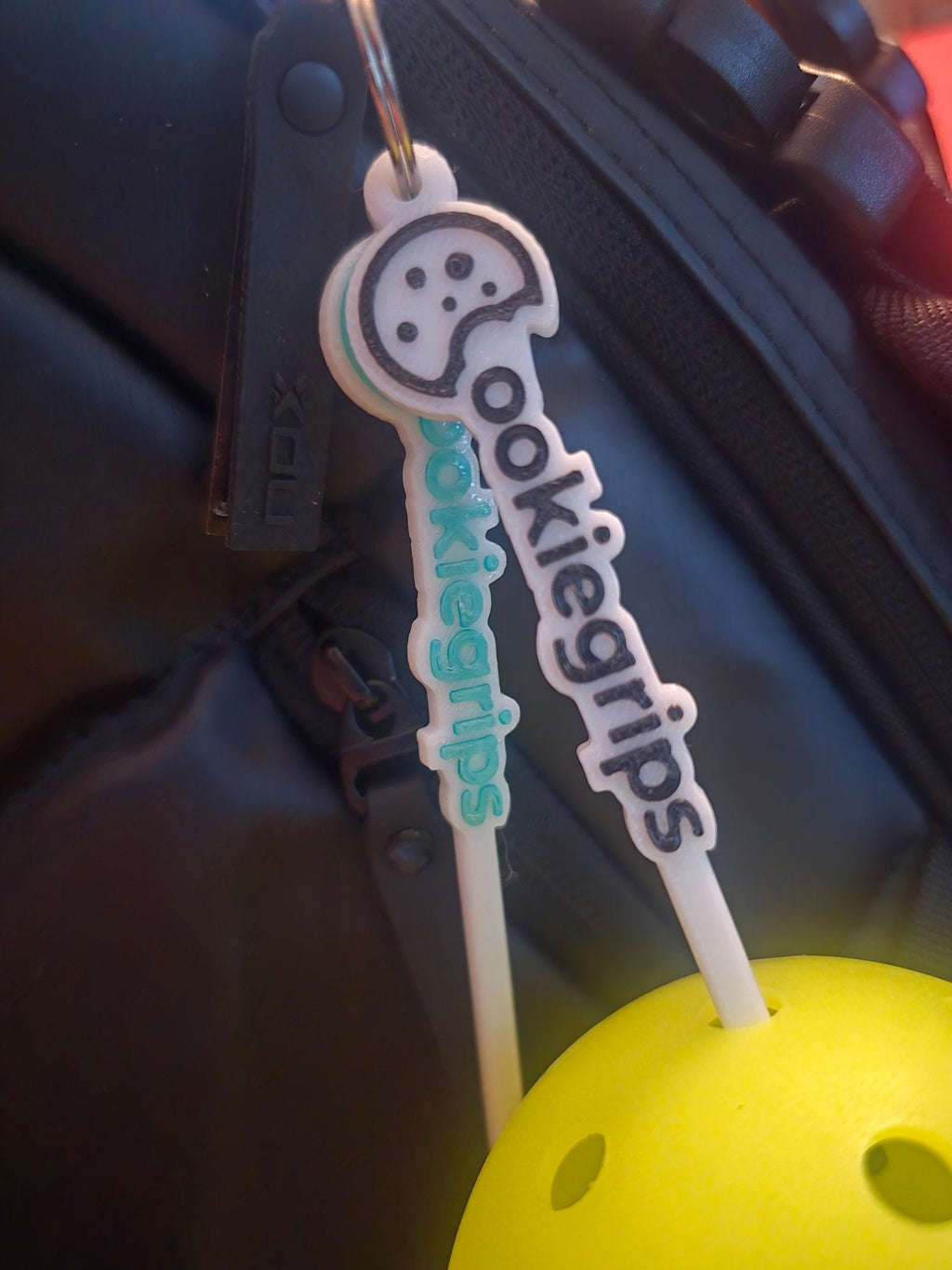 ookie grips ball pickers hanging from a bag
