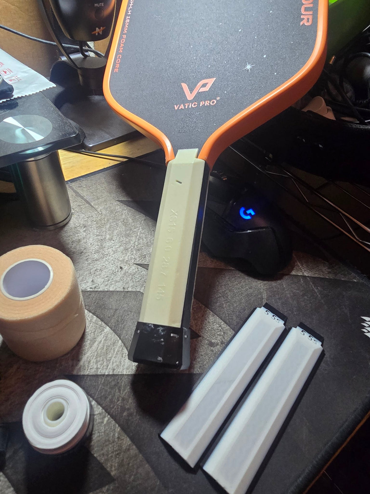 Cream grip panel installed on a paddle handle, with two spare white 5.5s panels beside it