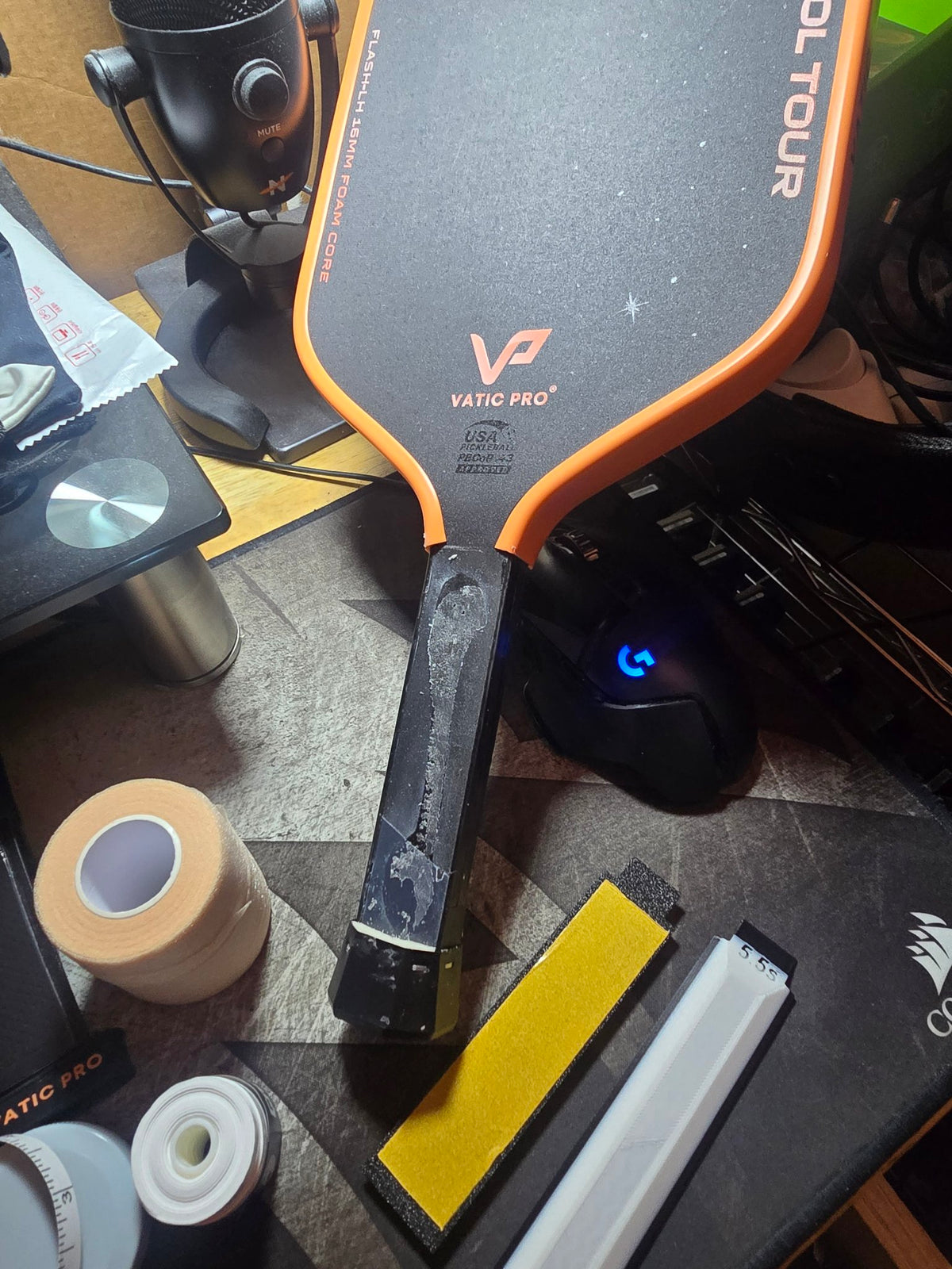 Paddle handle with the old grip stripped off, beside a yellow panel and a white 5.5s panel