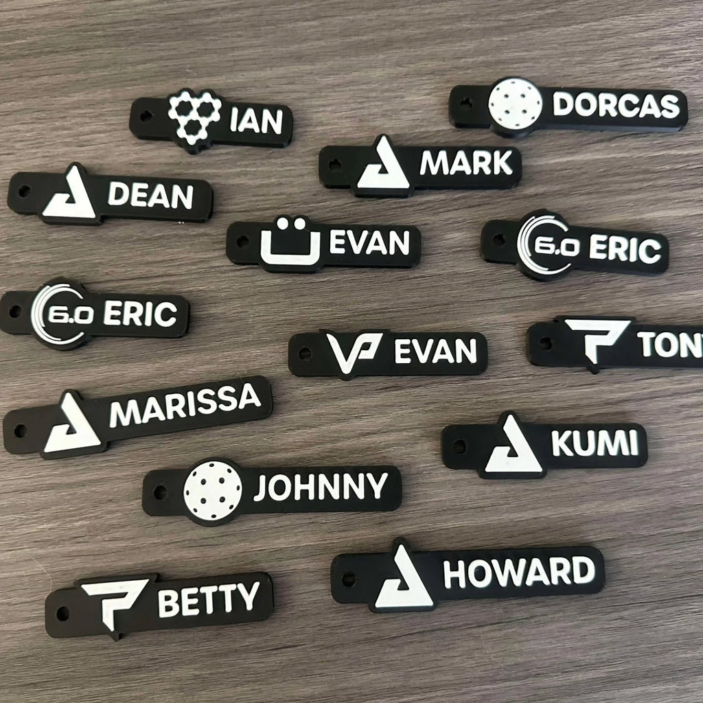 Name tag keychains laid out on wood