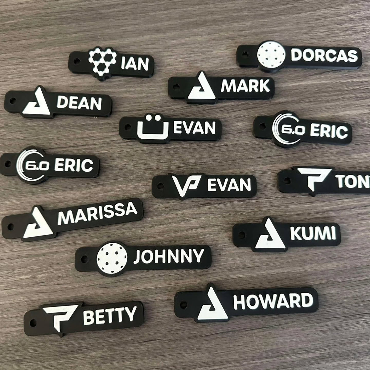 Name tag keychains laid out on wood