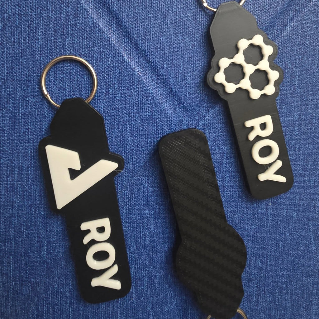 Black ROY keychains on denim
