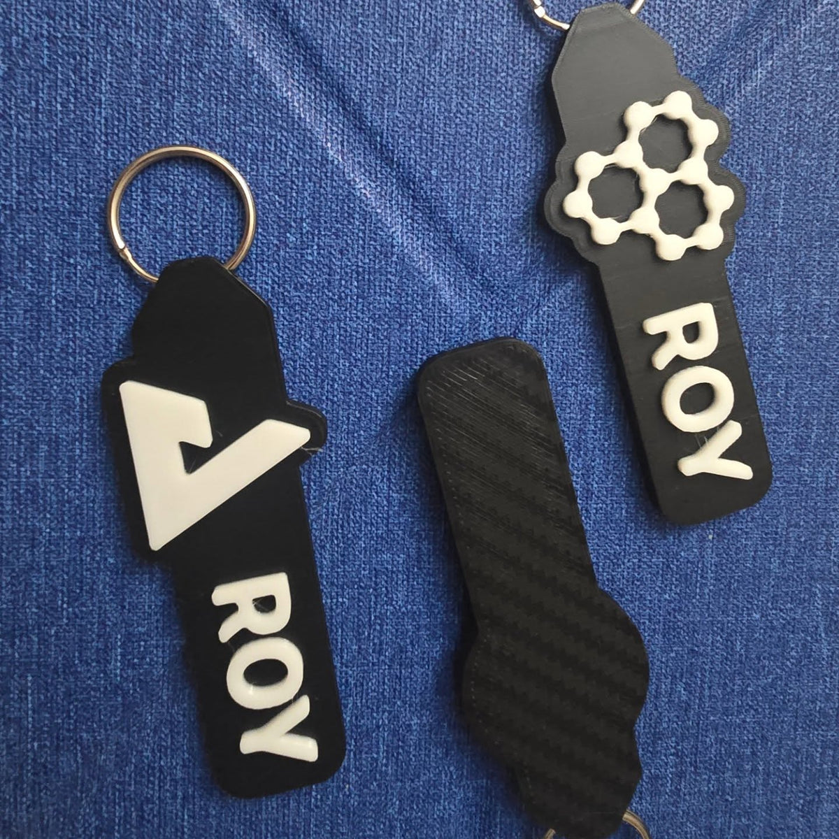 Black ROY keychains on denim
